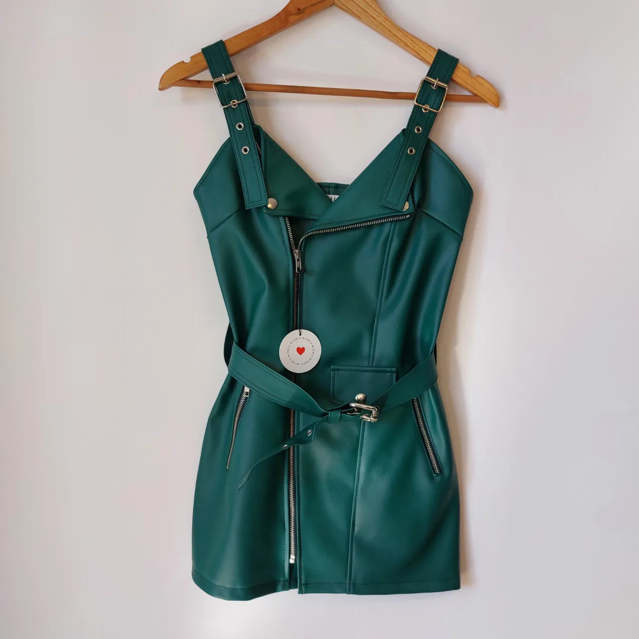 Vestido en cuero sintético, color verde, con tiras, cuello en V, cierre delantero y cinturón de hebilla