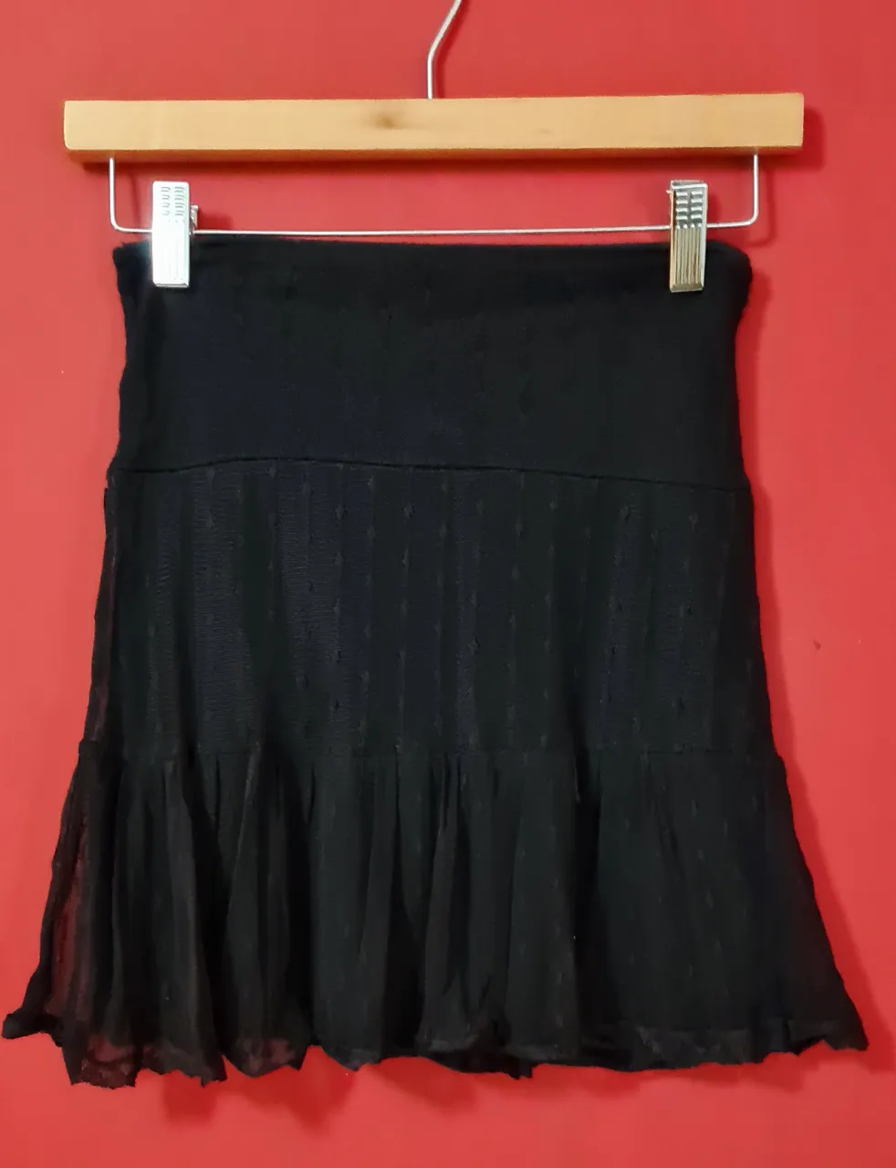 Pollera negra corta con detalles de textura y volado en la parte inferior. Ideal para un look canchero y femenino.