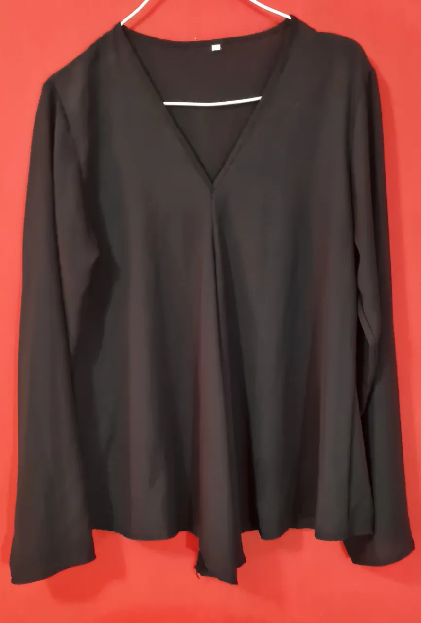 Remera negra de manga larga con cuello en V. Diseño suelto y moderno, ideal para un look casual y cómodo.