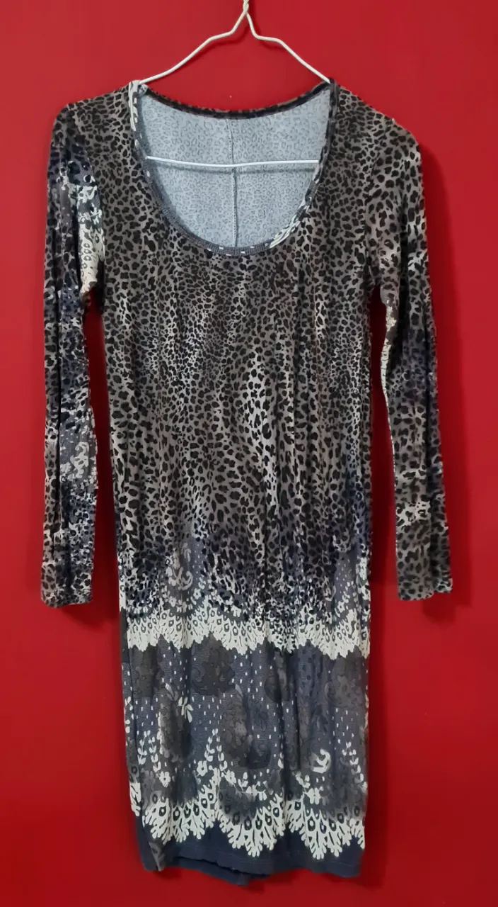 Vestido largo estampado con diseño de leopardo y detalles florales en la parte inferior. Manga larga y cuello redondo. Ideal para un look casual y canchero.