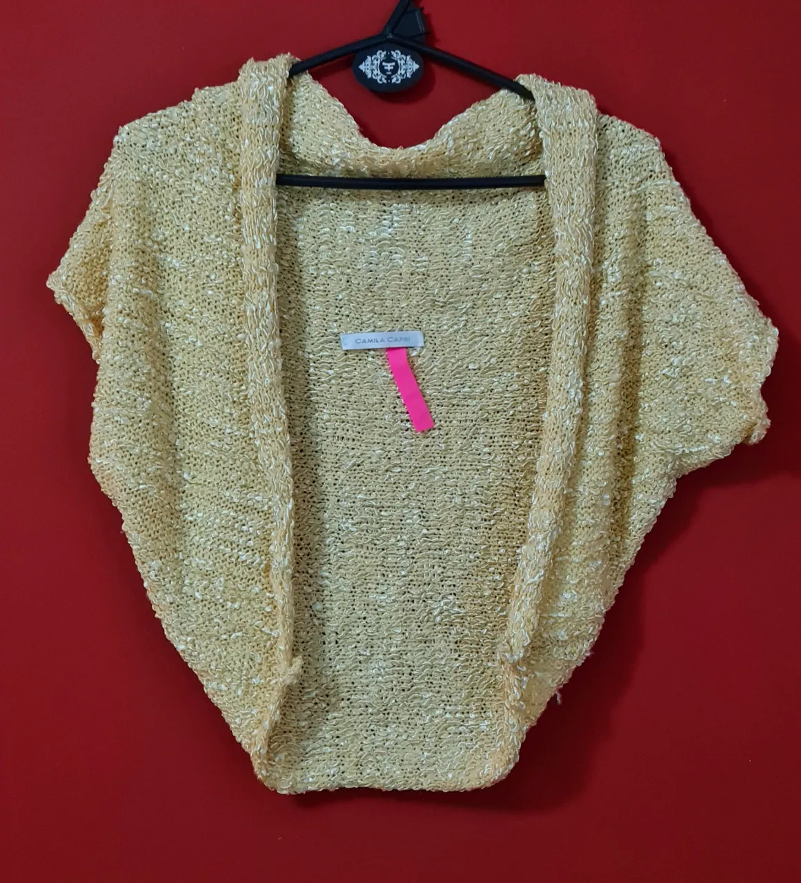 Cardigan tejido color amarillo pálido, con mangas cortas y diseño abierto. Ideal para un look casual y cómodo.
