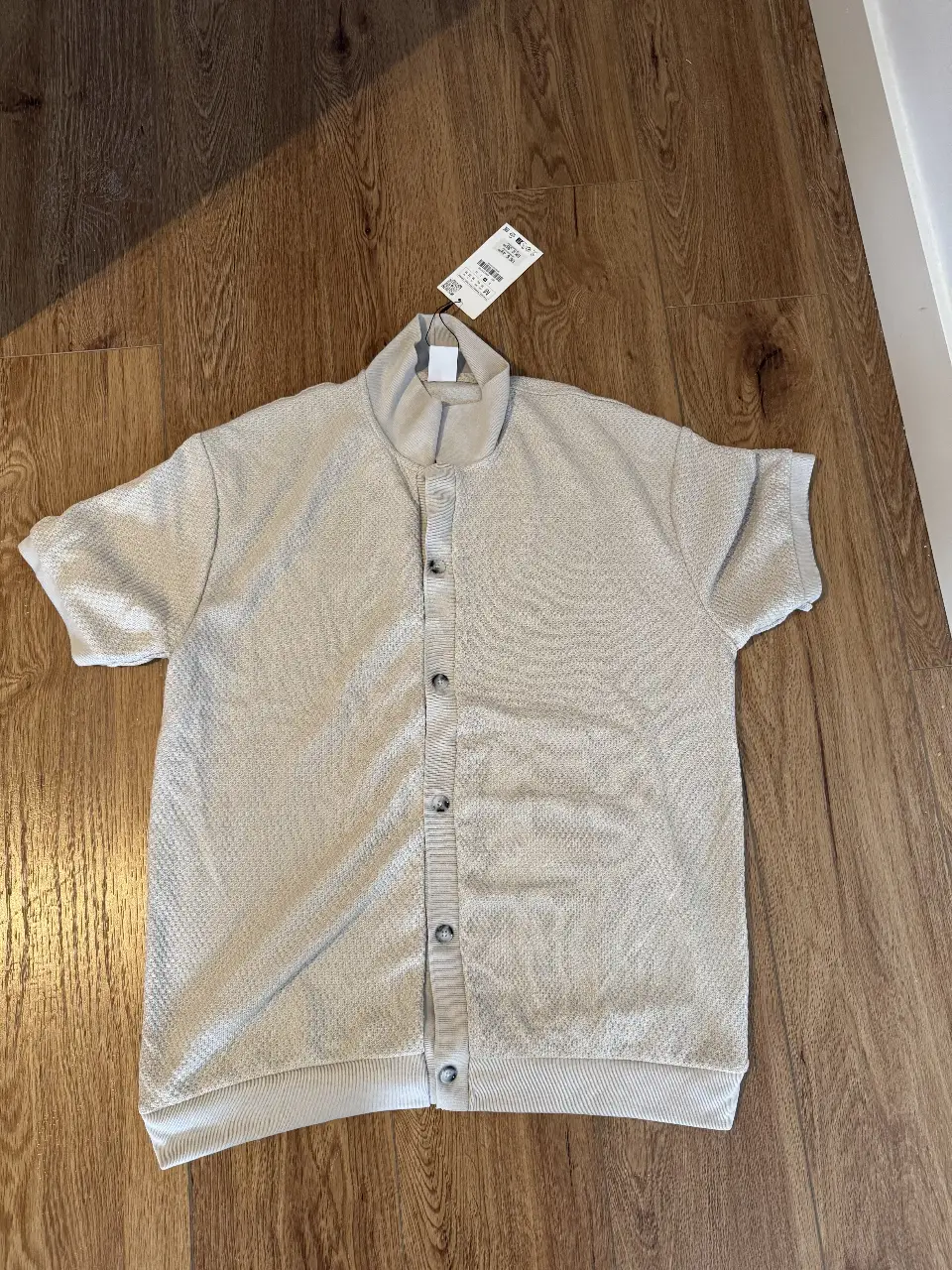 Camisa de hombre en color crudo, con cuello alto y cierre con botones. Ideal para un look casual y moderno.