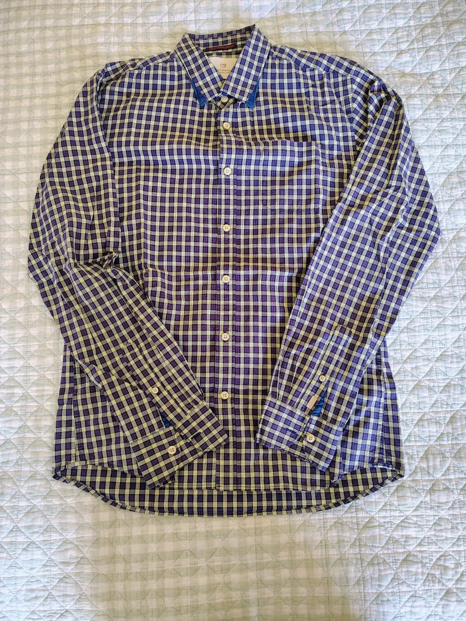 Camisa a cuadros de manga larga con botones al frente. Posee cuello camisero y un bolsillo en el pecho.