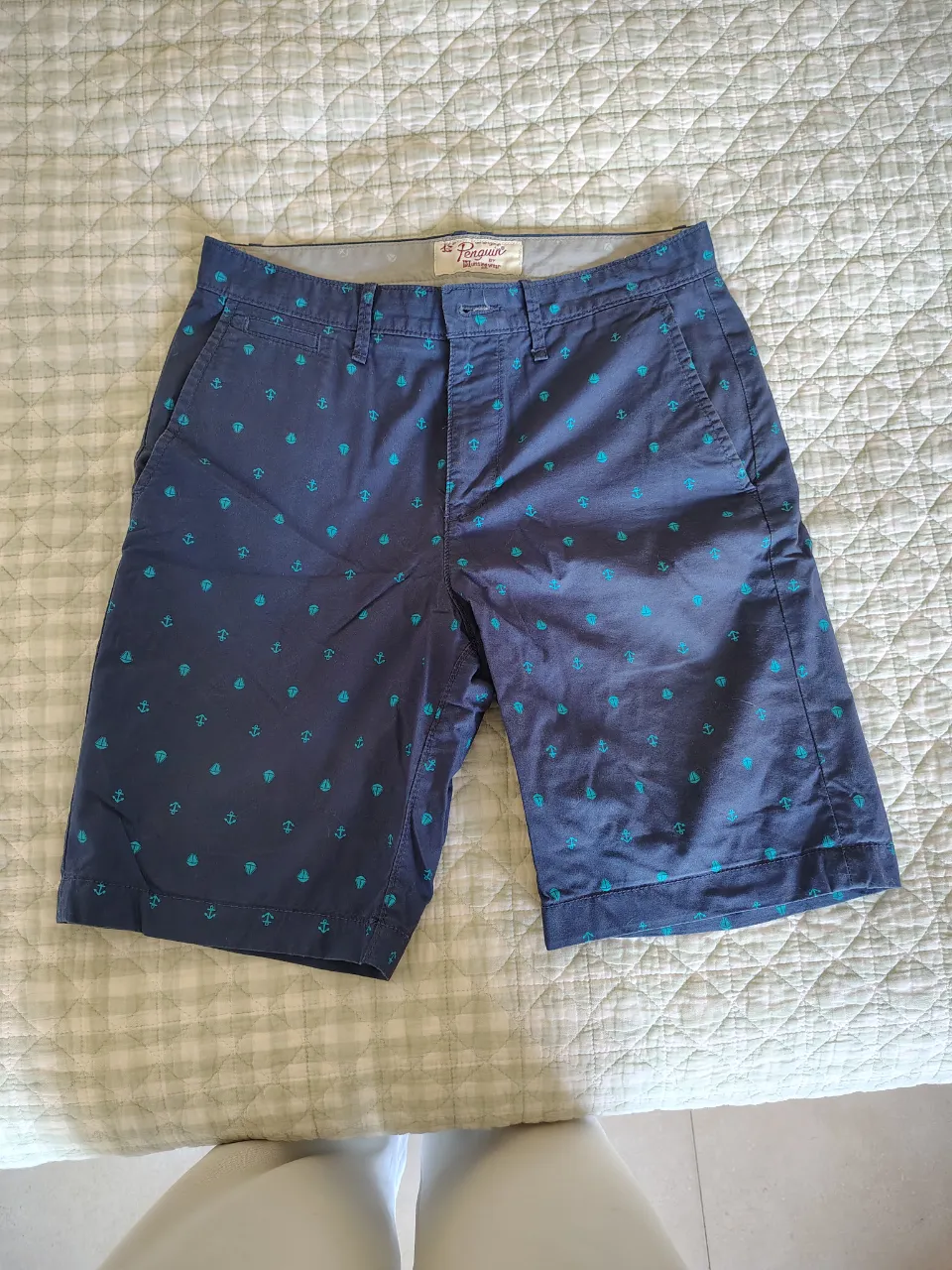 Shorts de gabardina azul marino con estampa de anclas y veleros en color turquesa. Modelo con bolsillos frontales y traseros.