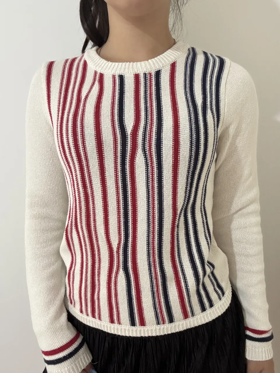 Sweater de tejido fino con rayas verticales en blanco, azul marino y rojo. Ideal para un look casual y cómodo.