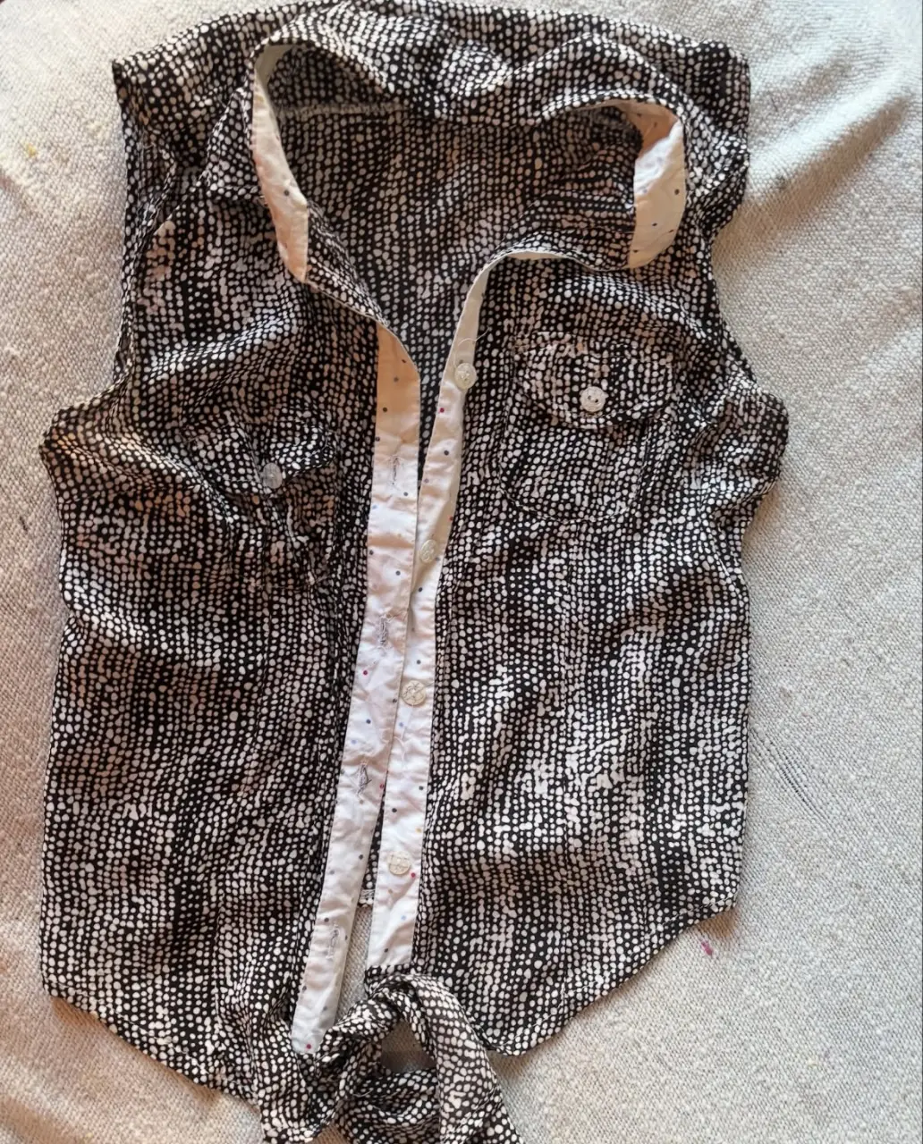 Blusa sin mangas con estampado de puntos en blanco y negro. Tiene botones y un lazo en la parte inferior. Marca Mintix Fashion, talle 2.