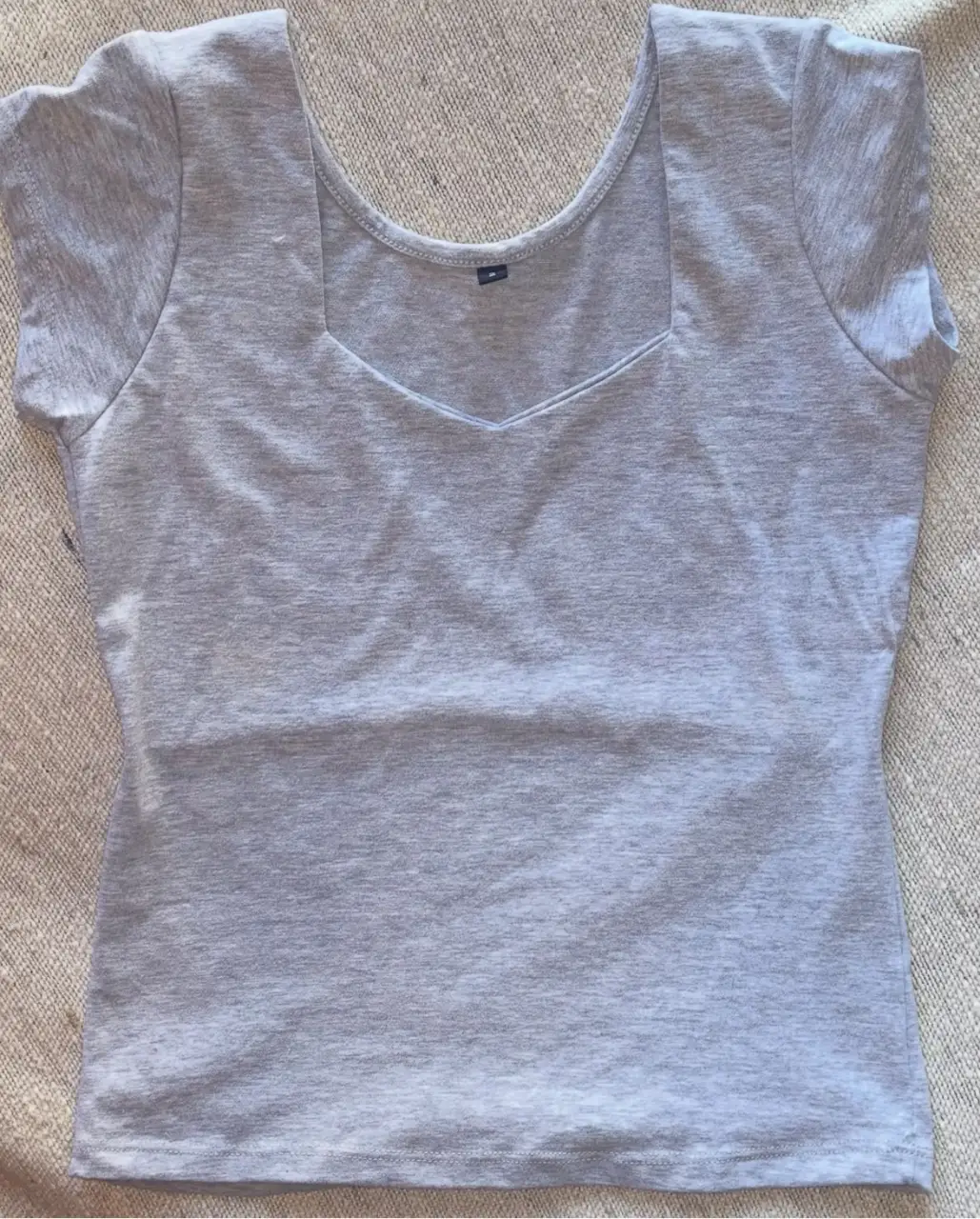 Remera de mujer gris, con cuello cuadrado y mangas cortas. Ideal para un look casual y cómodo.