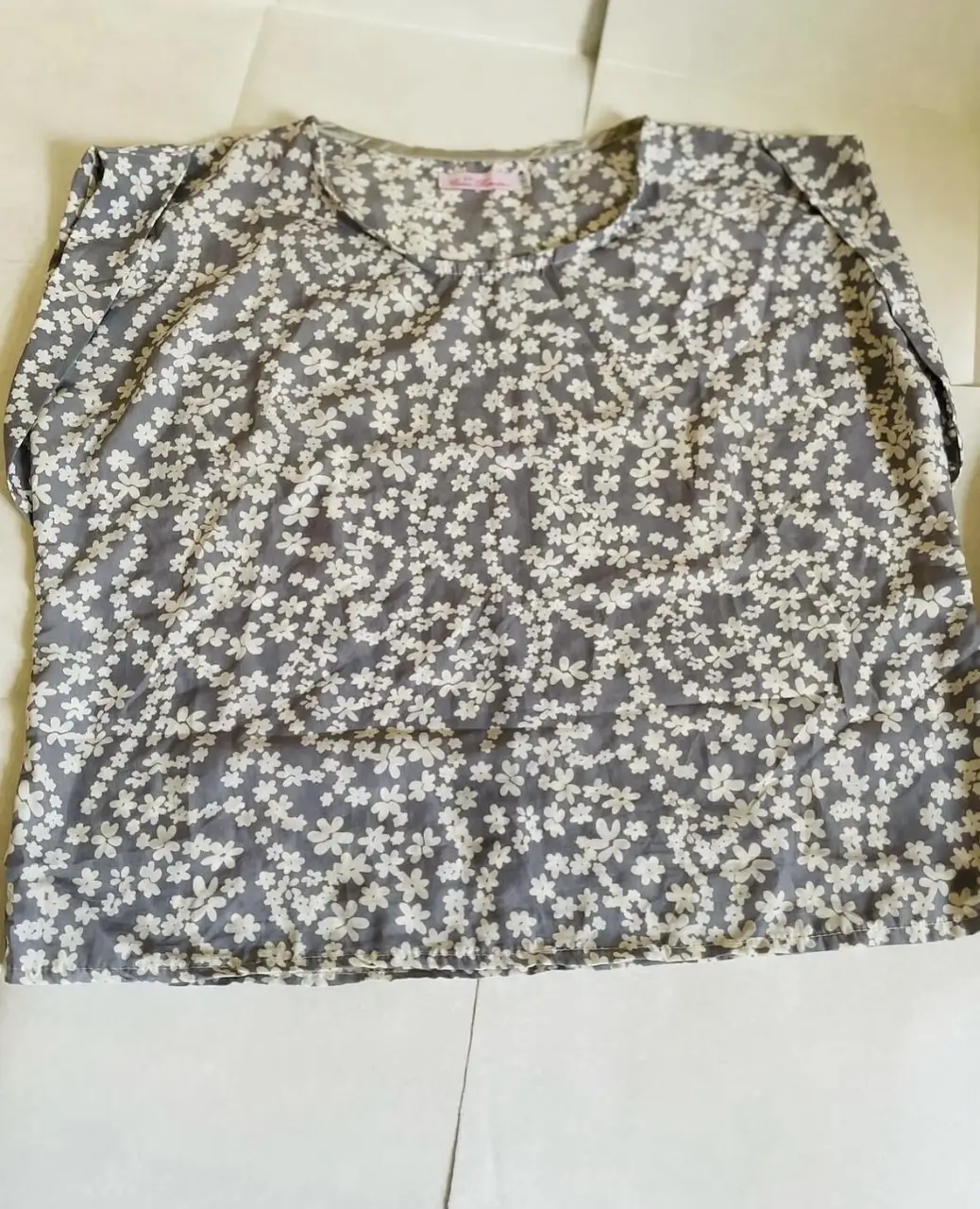 Blusa de mujer con estampado floral en tonos grises y blancos. Cuello en V y manga corta. Ideal para un look casual y fresco.