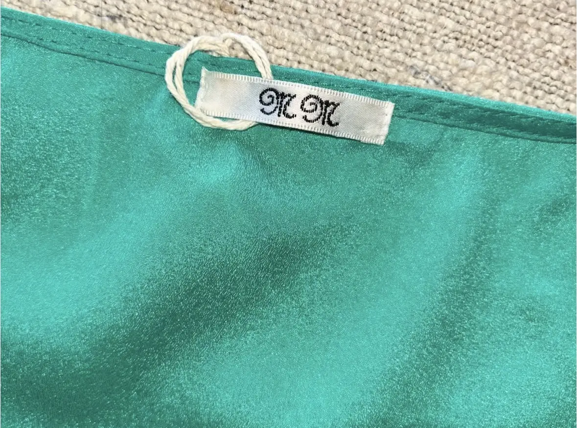 Blusa de seda verde con detalle de estrellas en relieve. Ideal para un look elegante y fresco.