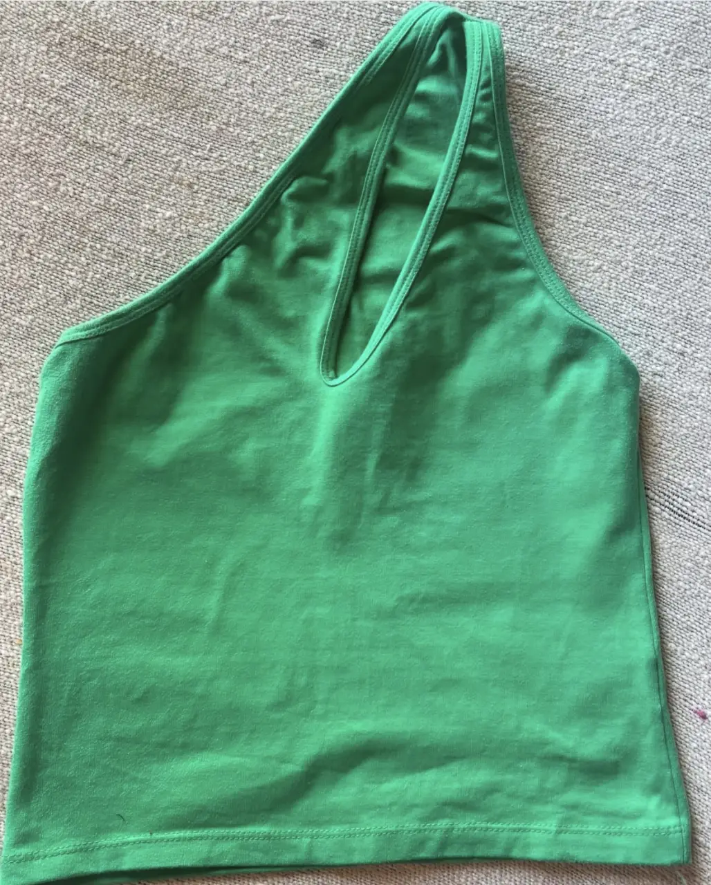 Top de un solo hombro, color verde, de la marca SWEET. Ideal para un look moderno y fresco.