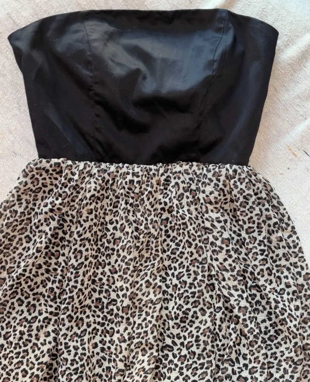 Vestido strapless con corpiño negro y falda con estampado de leopardo. Ideal para fiestas o salidas.