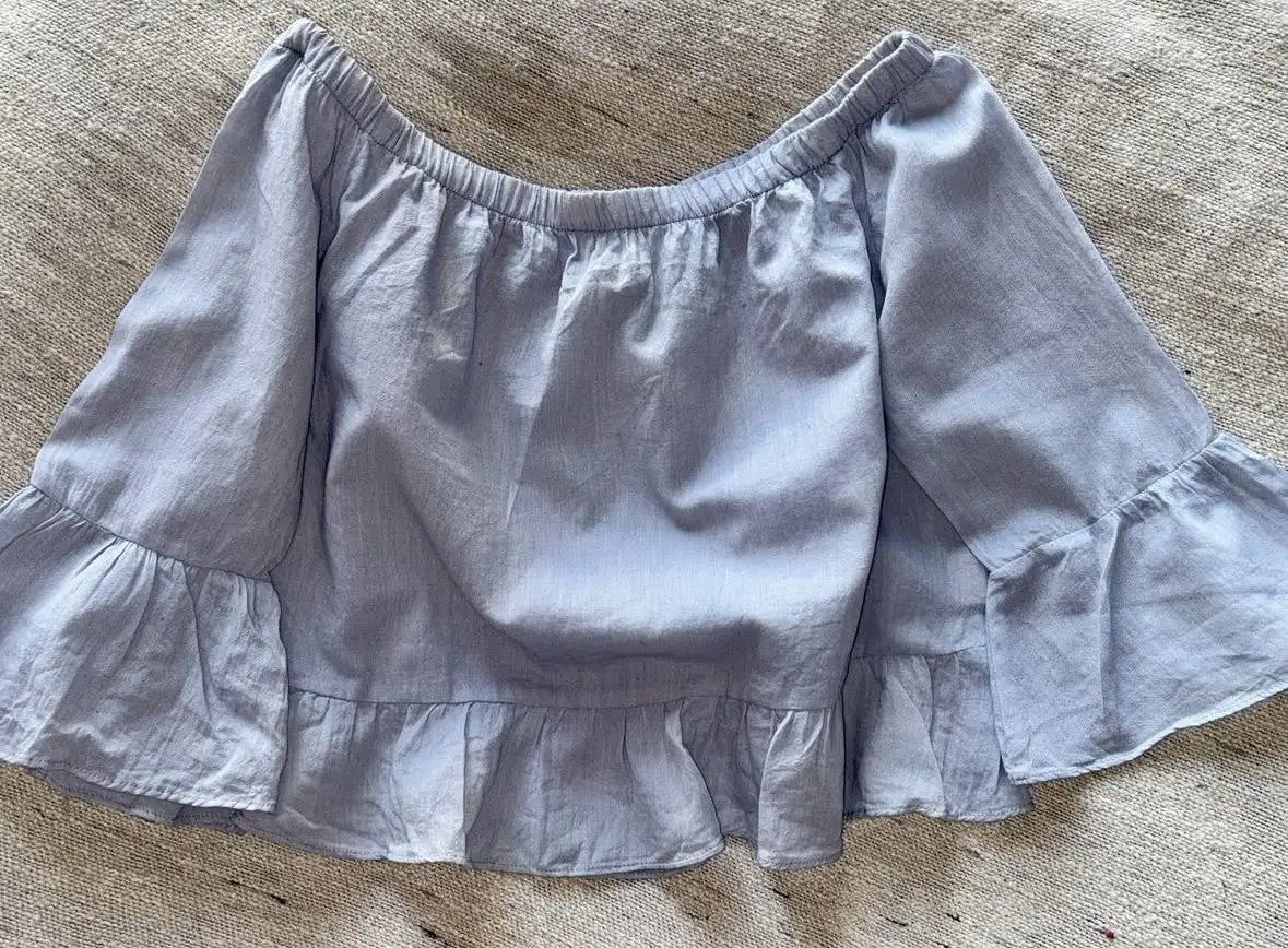 Blusa celeste con mangas acampanadas y hombros descubiertos. Ideal para un look casual y fresco en los días de calor. Talle 40.
