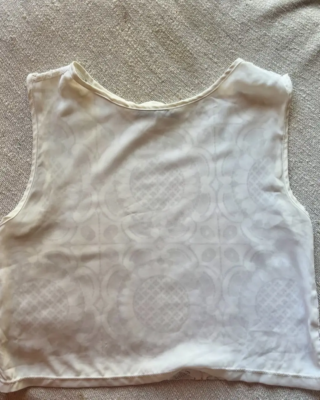 Top blanco de encaje con diseño floral. Ideal para un look casual y femenino. Talle 40.