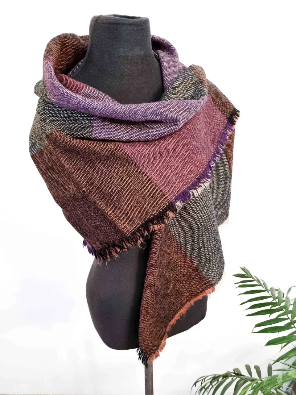 Bufanda de tejido a cuadros en tonos tierra y lilas. Posee flecos en los bordes. Medida 120x120 cm.