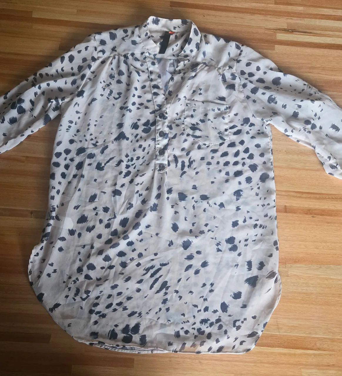 Camisa estampada con cuello mao y botones al frente. Posee mangas largas con puños y un bolsillo en el frente izquierdo. Medidas: largo 75cm, ancho de hombros 38cm, largo de mangas 47cm, sisa 49cm.