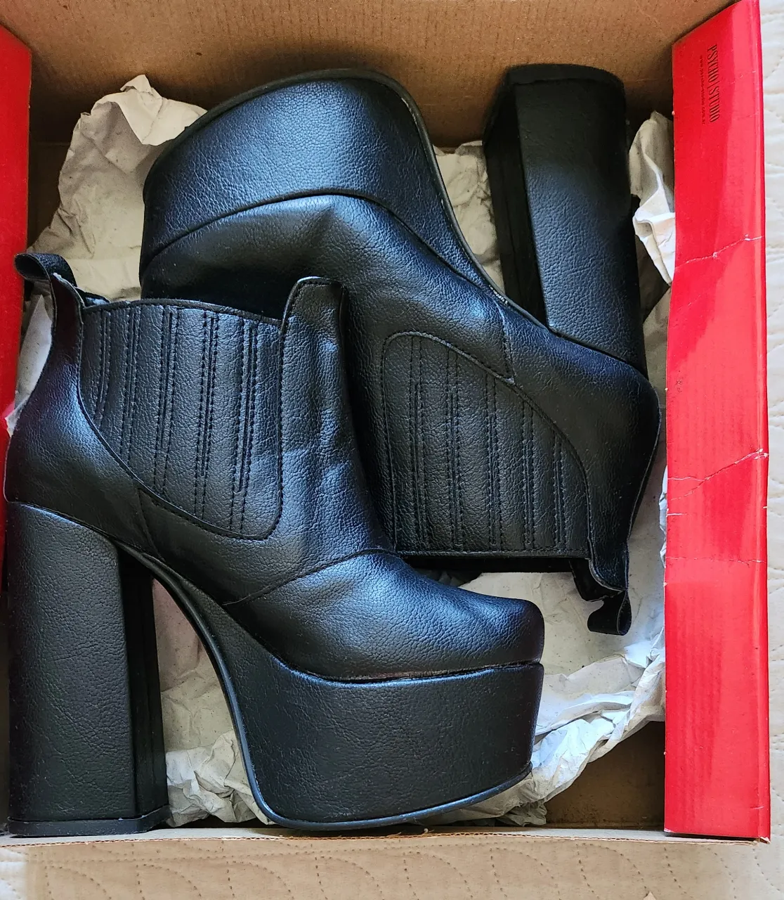 Botas negras con plataforma y taco grueso. Tienen elástico a los costados y tiras para calzar.