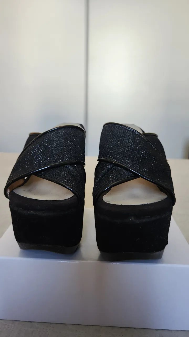 Sandalias negras con plataforma y tiras cruzadas.
