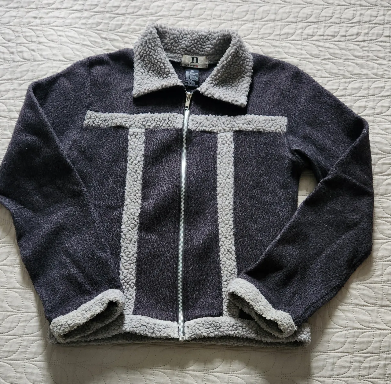 Campera de abrigo con cuello y puños de corderito. Cierre al frente. Diseño con franjas de corderito en el frente.