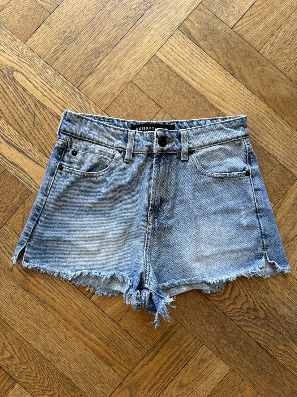 Shorts de jean tiro alto con roturas y detalles deshilachados en los bordes.