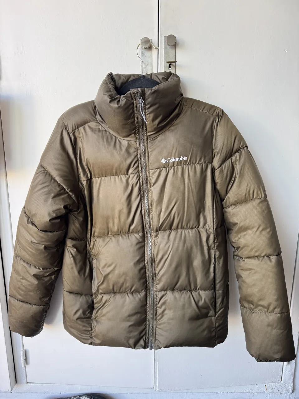 Campera puffer Columbia acolchada, ideal para el frío. Diseño moderno y funcional, perfecta para el día a día o actividades al aire libre. Color verde musgo, súper versátil.