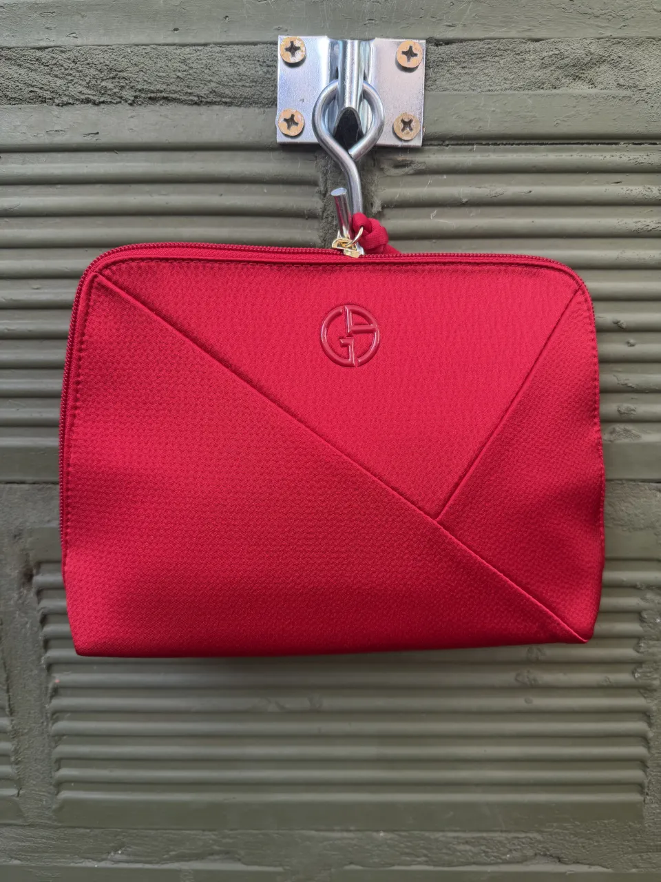 Neceser negro con cierre y logo de la marca Armani. Incluye una bolsa de tela negra con logo de Armani Beauty.