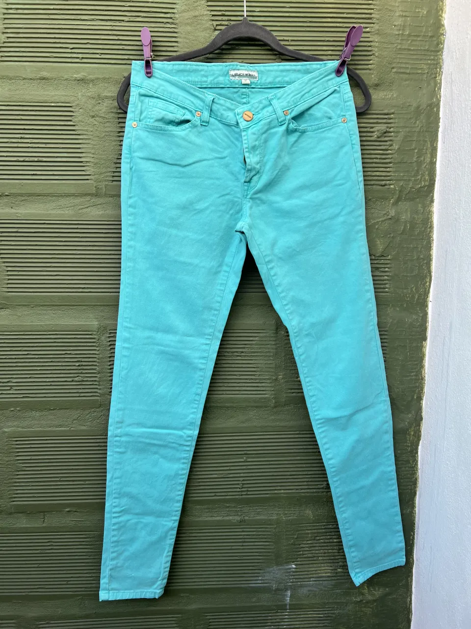 Jeans color turquesa. Cierre y botón dorado.