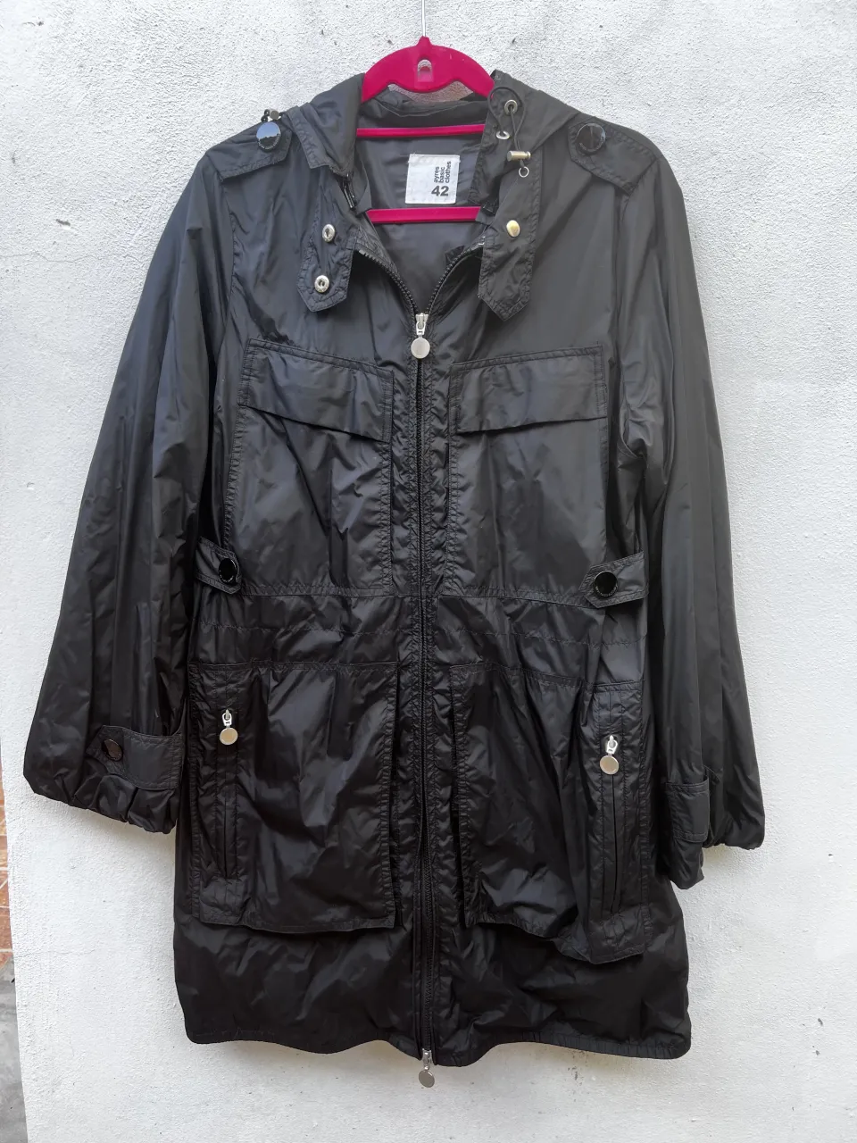 Campera negra con capucha, cierre al frente y bolsillos con solapa. Mangas con detalle de botones en los puños. Marca: ayres basic clothes.