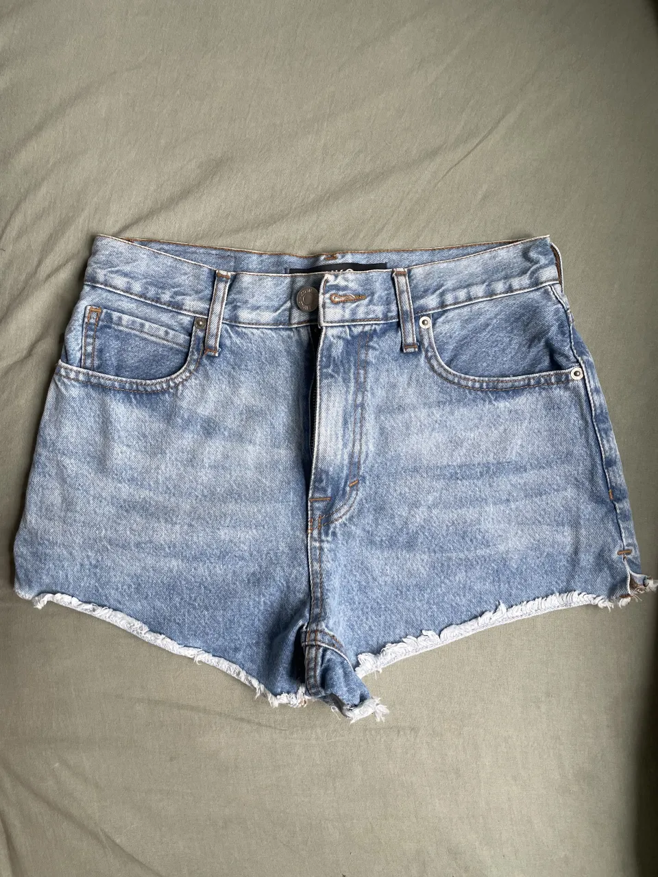 Short de jean tiro alto con roturas y detalles desflecados en el ruedo. MUY POCO USO. Posee bolsillos delanteros y traseros.