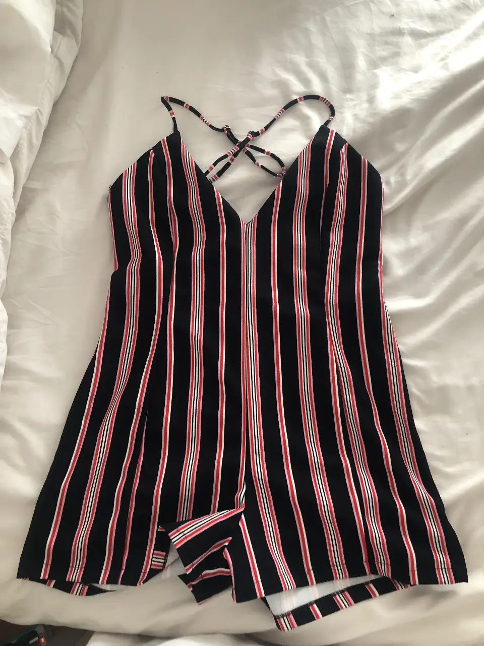 Mono corto con tirantes cruzados en la espalda, a rayas verticales en negro, rojo y blanco. Ideal para el verano.