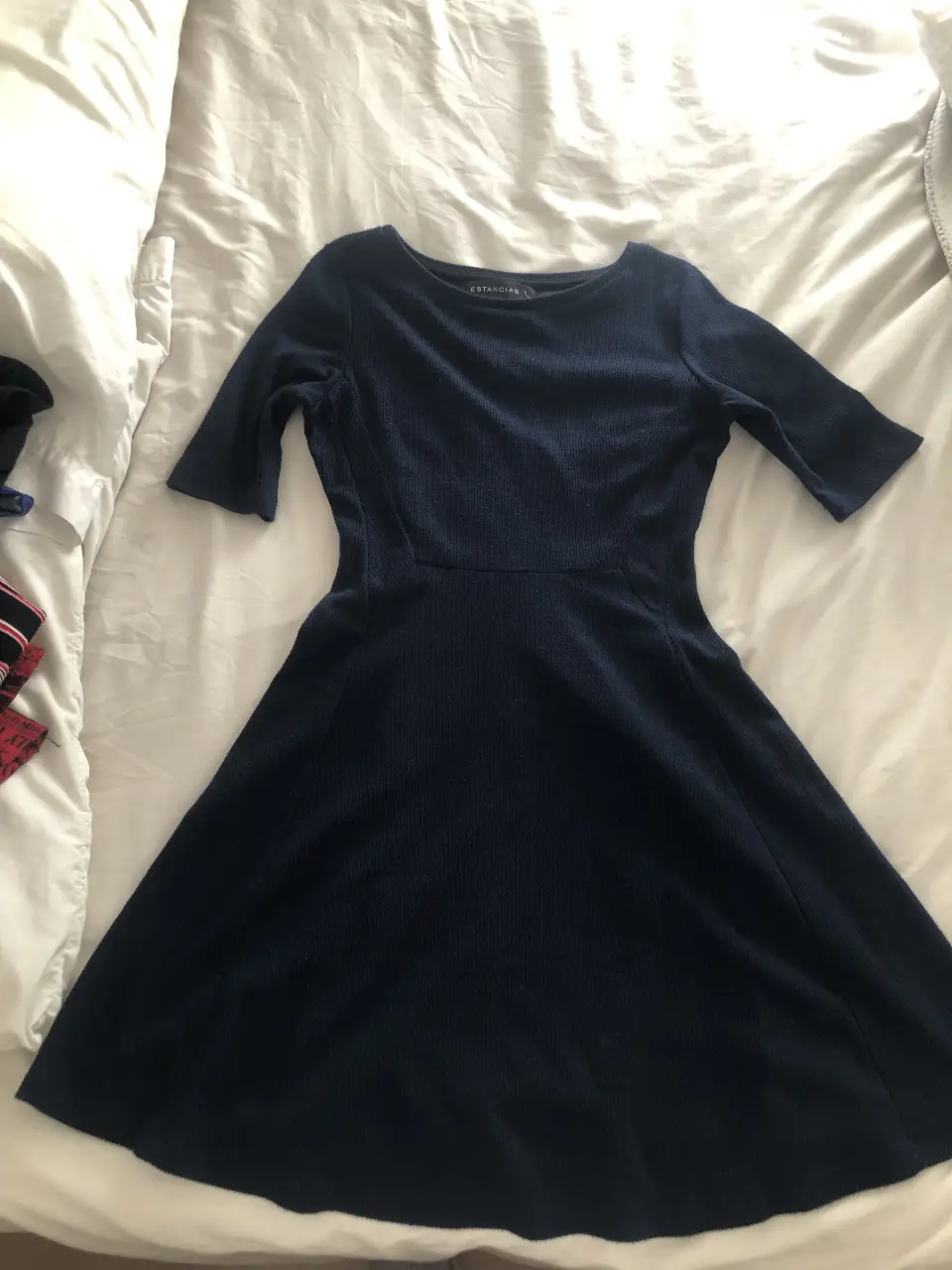 Vestido midi de color azul marino, con mangas 3/4 y corte en la cintura que favorece la silueta. Ideal para un look elegante y versátil.