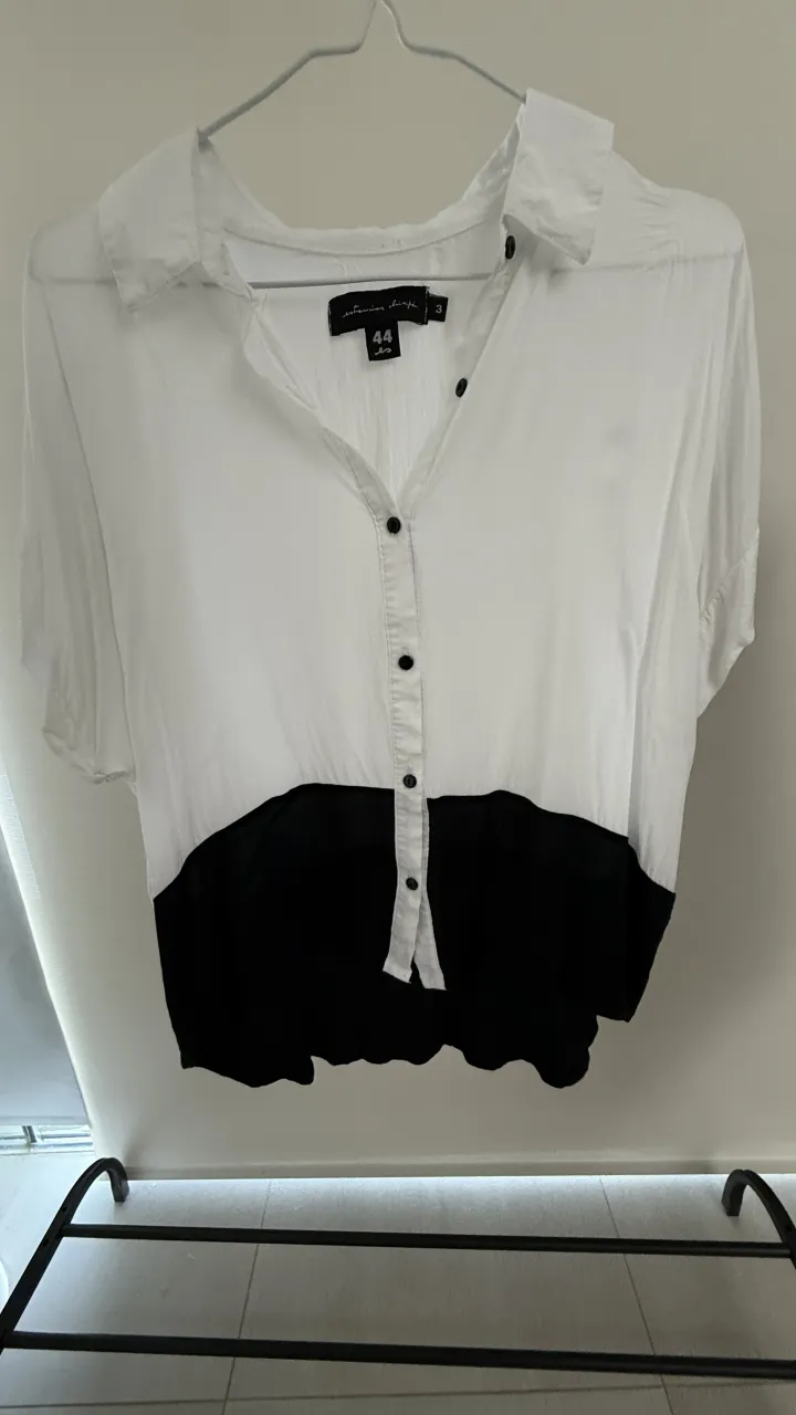 Camisa blanca y negra con botones al frente y mangas cortas.
Talle 3 de la marca, va hasta un M