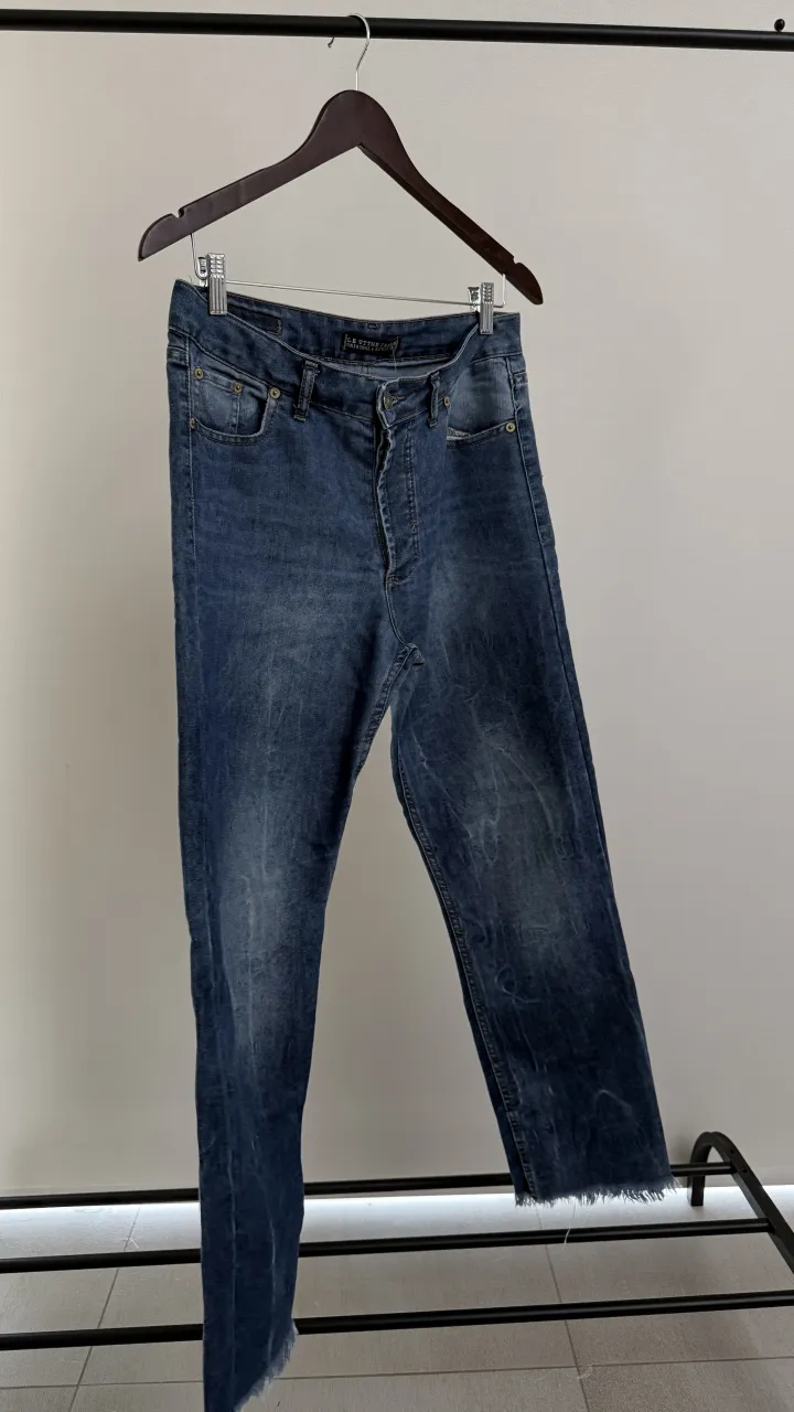 Jeans de denim azul con desgastes y roturas en los bajos. Cierre de botón y cierre. Marca Le uttle, medidas en las fotos