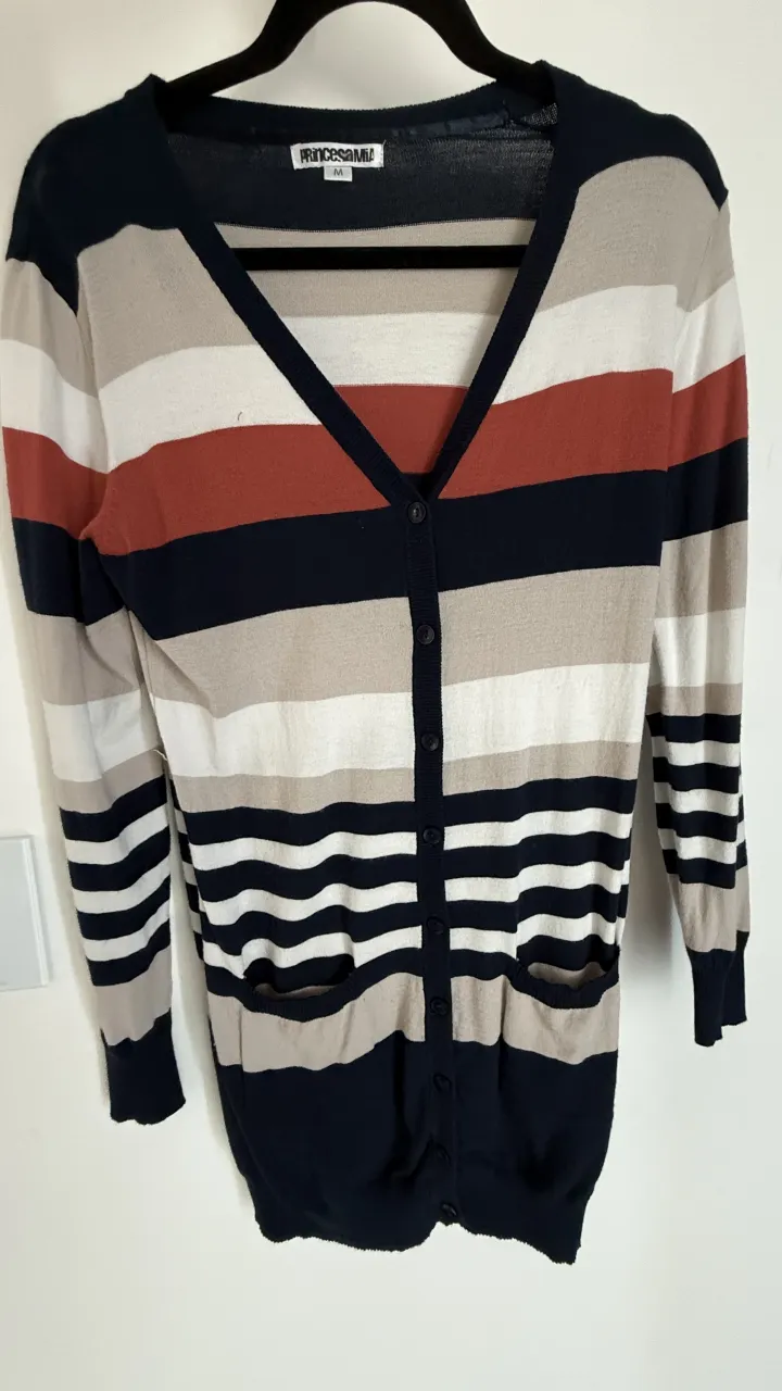 Cardigan a rayas multicolor (azul marino, rojo, blanco y beige) con botones al frente y bolsillos. medidas, hombros 44, largo total 64.