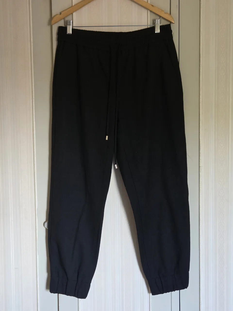 Pantalón  negro con cordón ajustable en la cintura y puño elastizado en los tobillos.