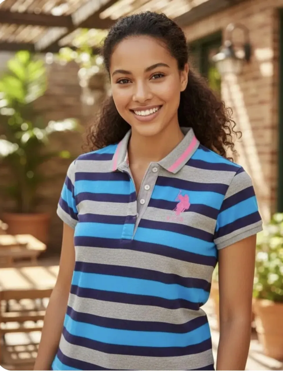 Remera polo a rayas azules, grises y negras. Tiene un logo rosa bordado en el frente y un número rosa en la manga. Tengo dos unidades, xl.