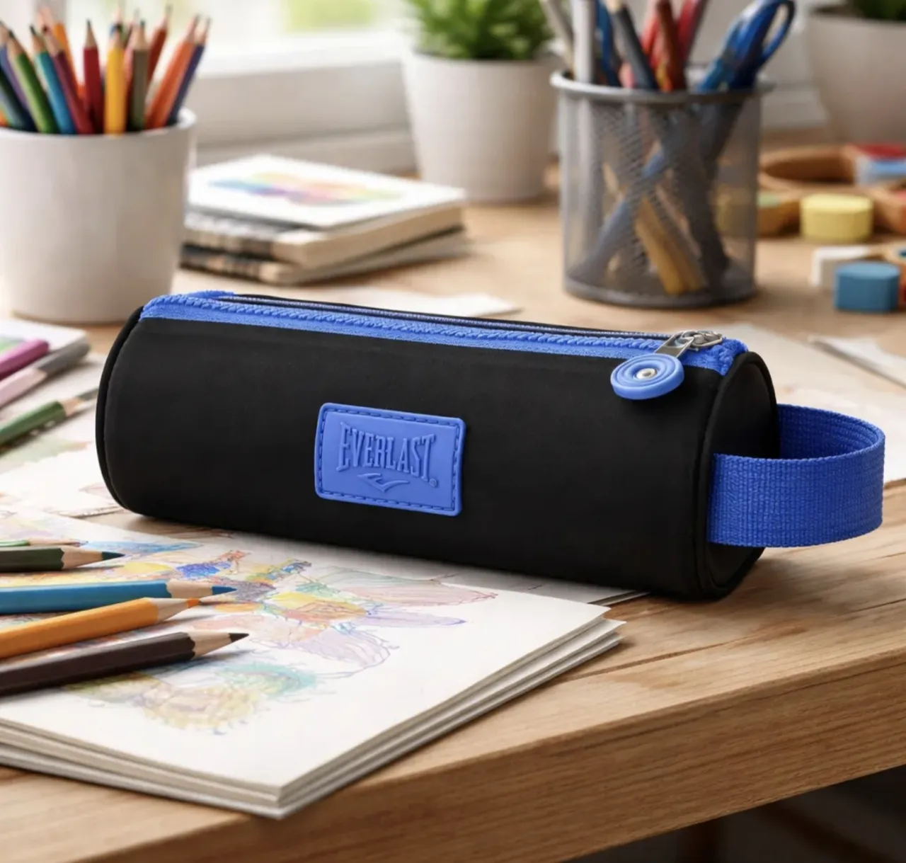 Estuche cilíndrico negro con cierre azul y detalle de logo rectangular azul de la marca Everlast.