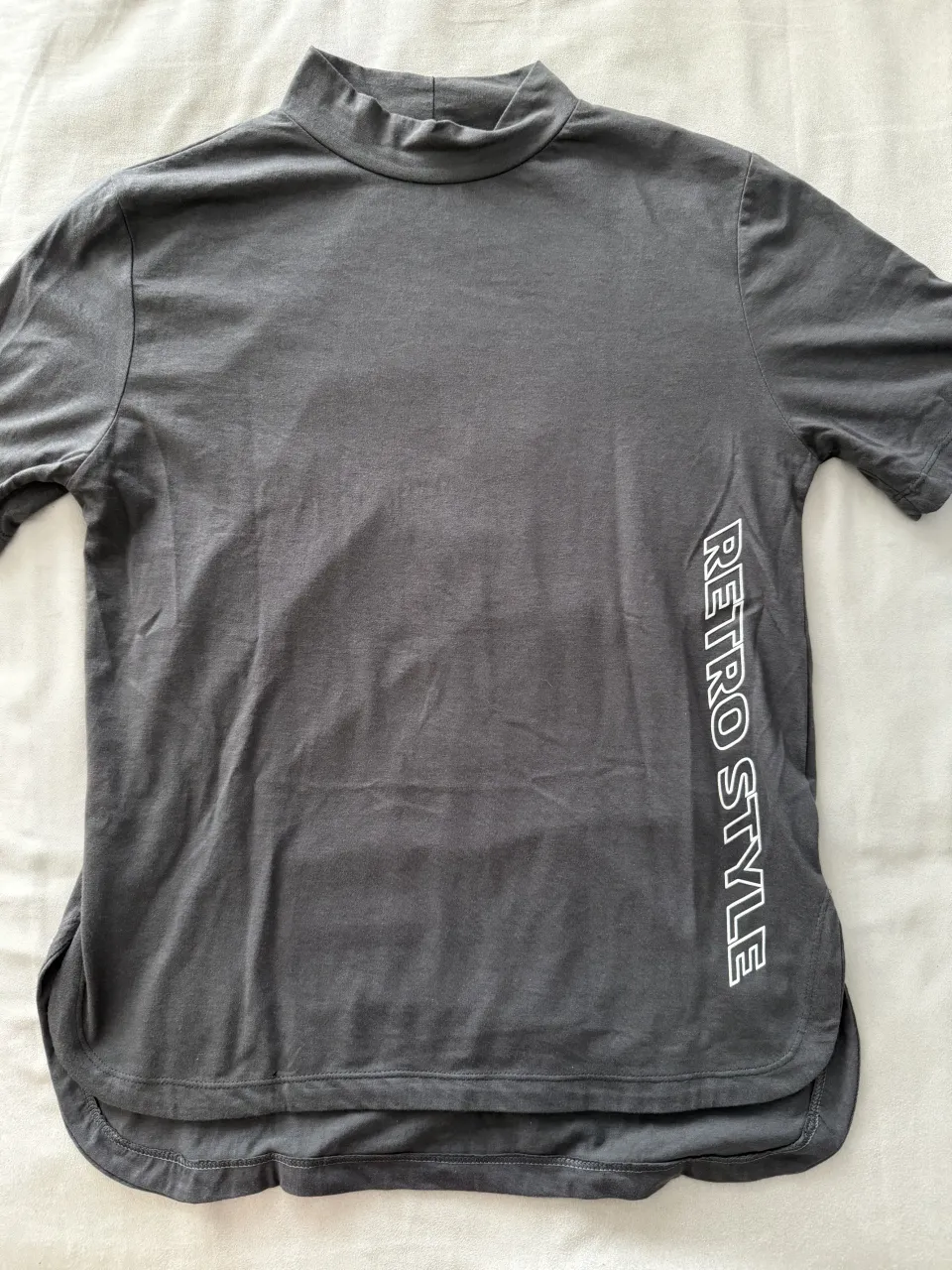 Remera gris oscuro con cuello alto y estampa lateral "Retro Style". Ideal para un look casual y moderno.