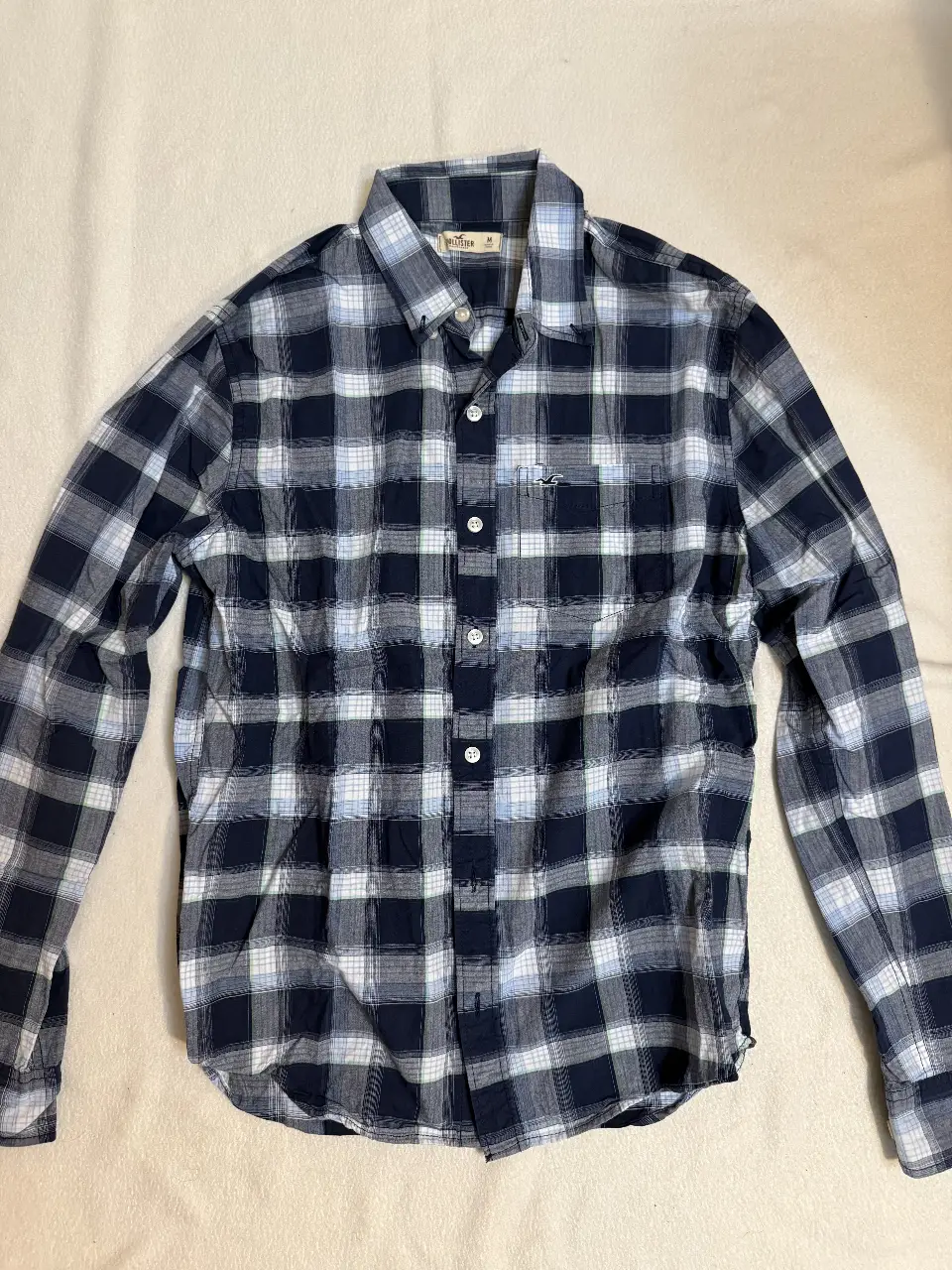 Camisa a cuadros Hollister para hombre, manga larga, en tonos azul y blanco. Ideal para un look casual y moderno.