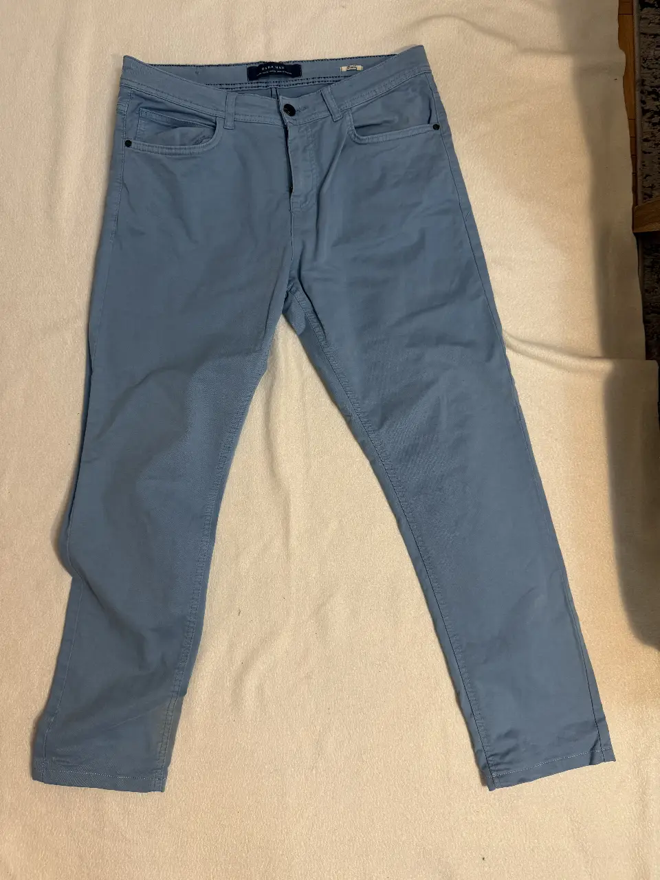 Pantalón chino celeste de hombre, de la marca Zara Man. Corte recto, ideal para un look casual y cómodo.