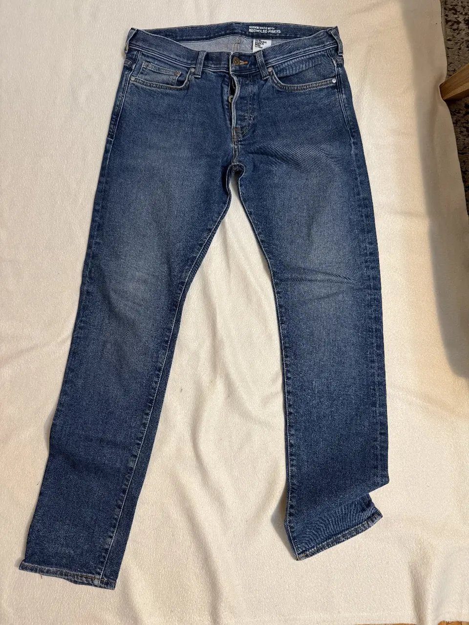 Jeans de hombre, corte recto, color azul. Confeccionado con fibras recicladas. Ideal para un look casual y versátil.