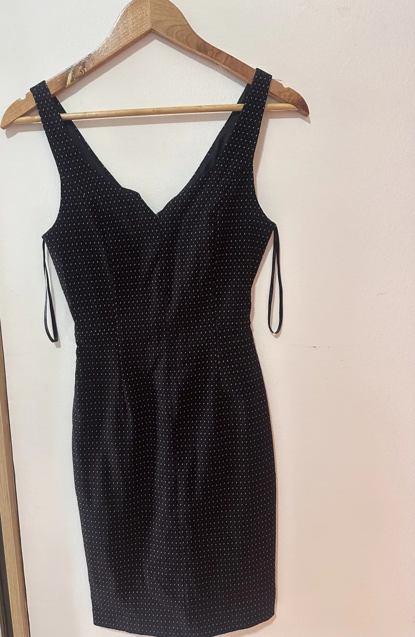 Vestido negro con pequeños detalles blancos y rojos. Breteles finos y escote en V.