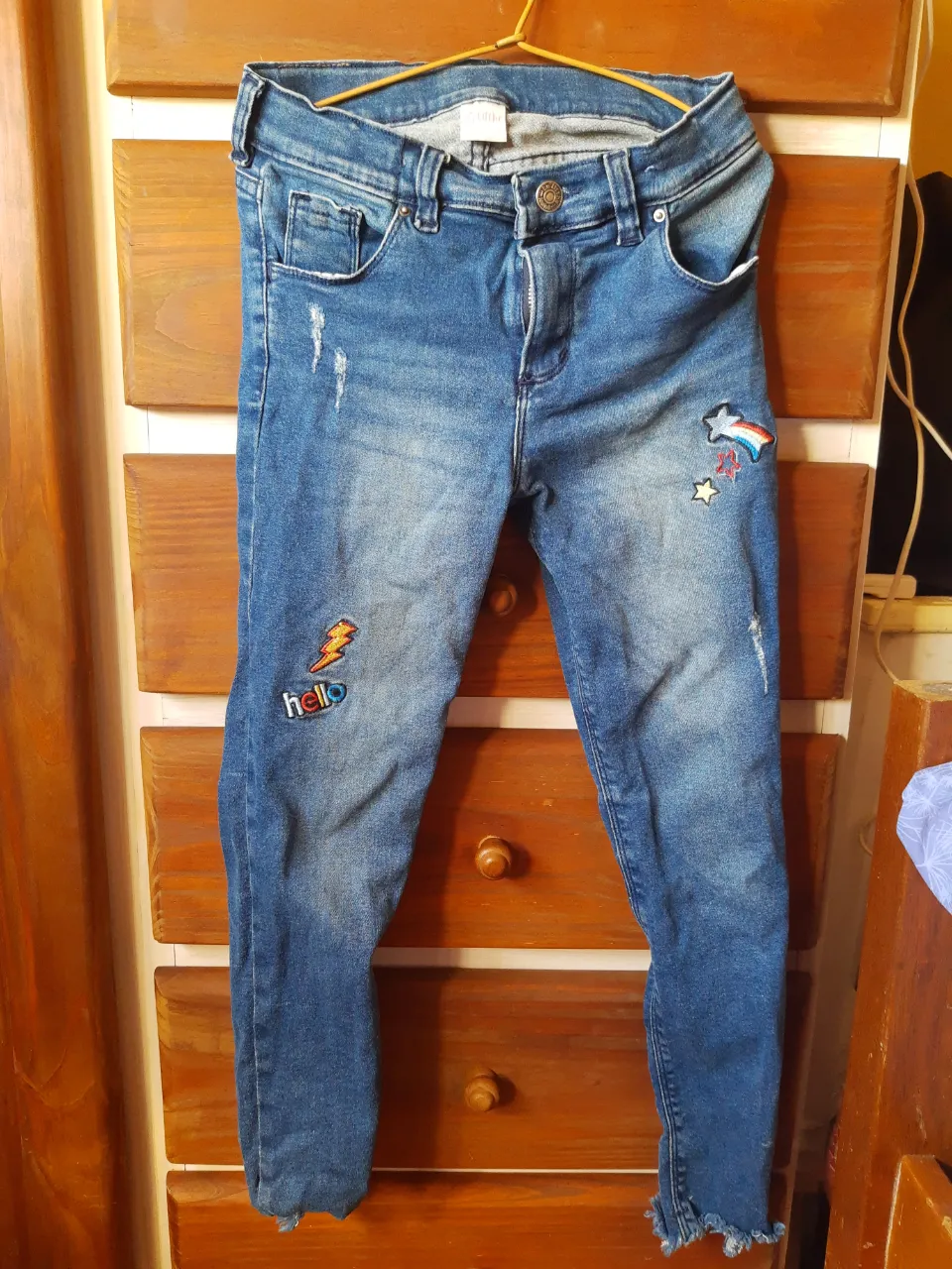 Jeans de denim azul con roturas y parches de arcoíris y rayo. Los bajos tienen un acabado deshilachado.
 t12 con diseño de estampas en excelente estado. medidas: 75cm largo 35cm ancho.