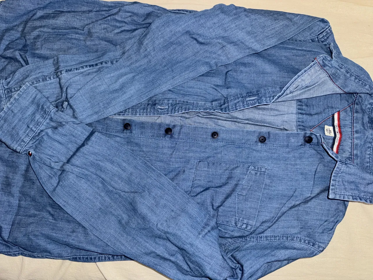 Camisa de jean azul marca Tommy Hilfiger con botones al frente y bolsillo en el pecho.