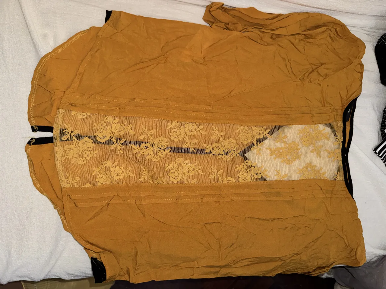 Blusa  color mostaza marca Sweet con detalles de encaje floral en la parte delantera y botones en la parte trasera. 