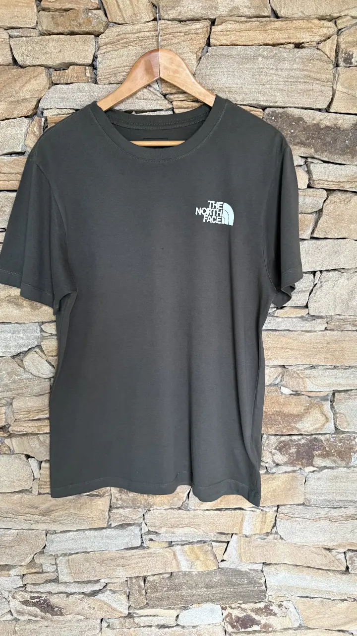 Remera The North Face de hombre, color verde oscuro con logo blanco en el pecho y en la espalda. Ideal para un look casual y cómodo.