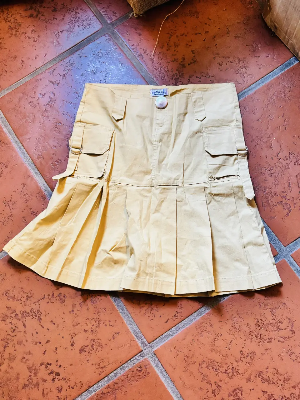 Pollera estilo cargo de color beige, con bolsillos y detalles de presillas. Ideal para un look utilitario y casual.