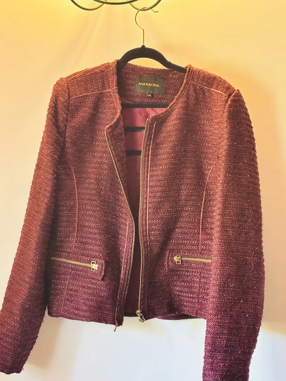 Elegante blazer de mujer en tono borgoña, ideal para un look sofisticado. Confeccionado en tejido texturizado, presenta cierre con cremallera dorada y bolsillos funcionales. Perfecto para ocasiones formales o para darle un toque chic a tu outfit diario.