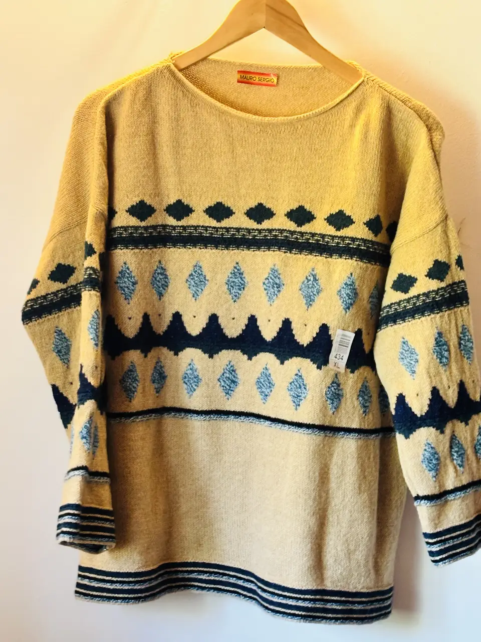 Sweater largo de lana con diseño geométrico en tonos amarillo y azul. Ideal para un look retro y abrigado. El precio es por unidad.