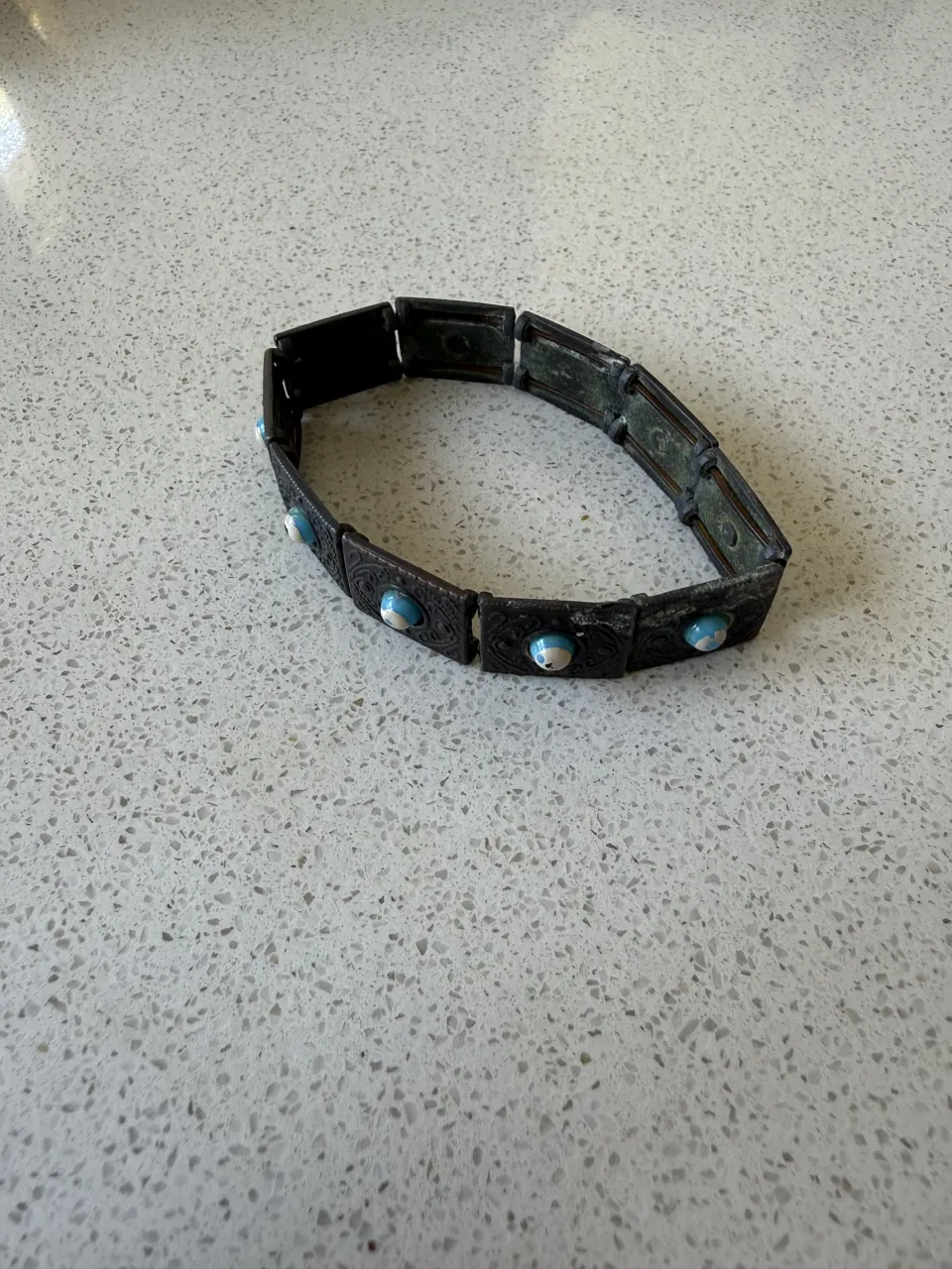 Pulsera de eslabones con detalles grabados y piedras turquesas. Un accesorio único para darle un toque especial a tu look.