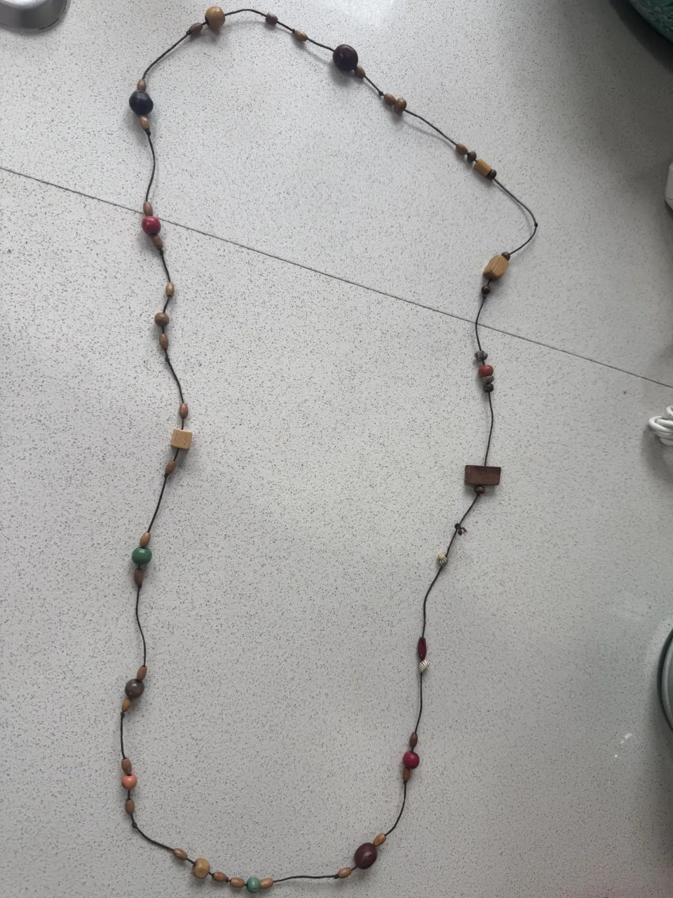 Collar largo con cuentas de madera y detalles en tonos tierra. Perfecto para darle un toque bohemio y natural a tu look.